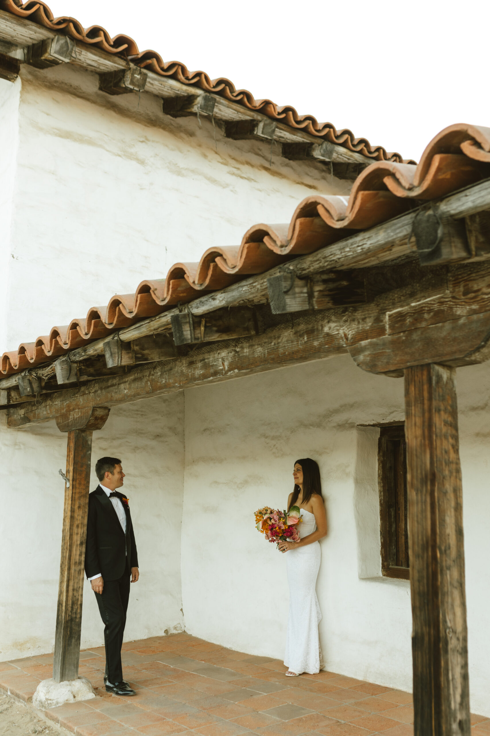 Bride and groom looking at each other outside of a wedding venue in Santa Barbara.